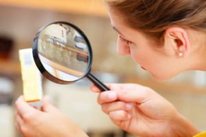 Woman inspecting butter with magnifying glass.